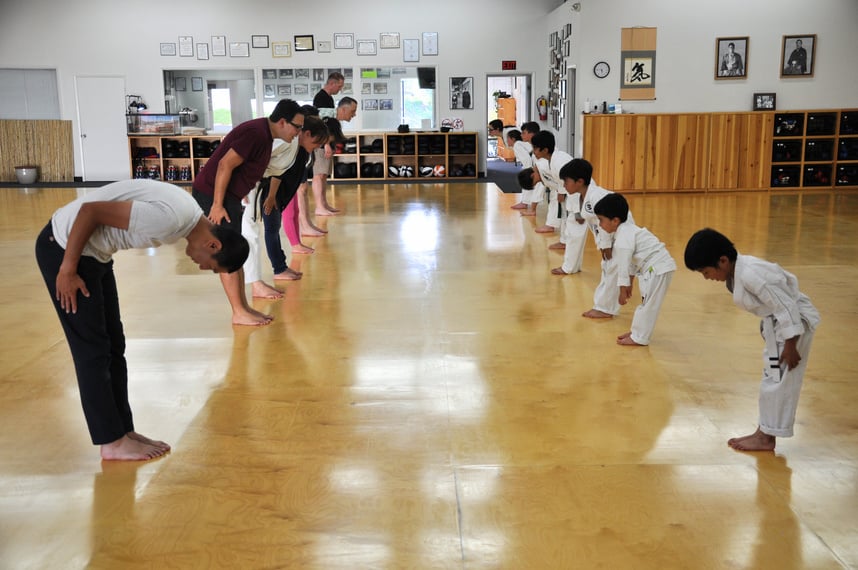 parents and children practicing karate in a dojo