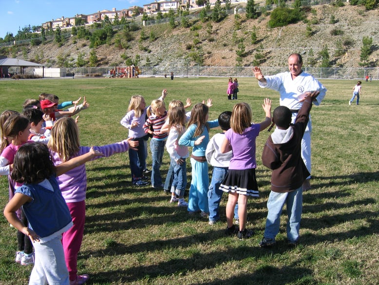 children practicing karate outside